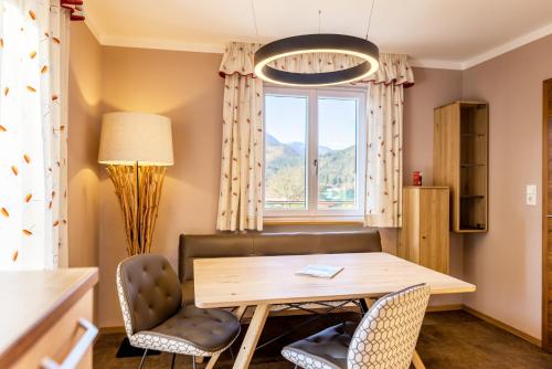 a dining room with a table and chairs and a window at Haus Bergblick in Fuschl am See