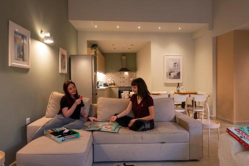 two women sitting on a couch in a living room at Linas Home - Kalamata Mediterranean Villas in Kalamata