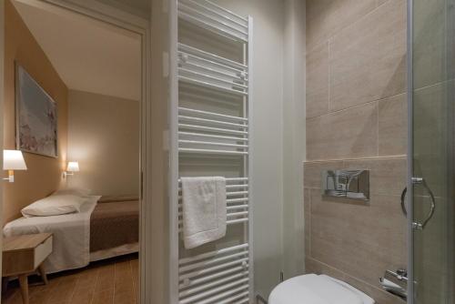a bathroom with a shower with a toilet and a bed at Linas Home - Kalamata Mediterranean Villas in Kalamata