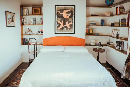 a bedroom with a large white bed and shelves at Labella Villa in Viterbo