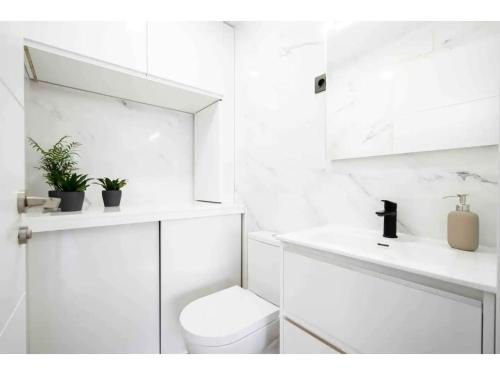 a white bathroom with a toilet and a sink at Precioso apartamento a pie de calle - Retiro- Dr Laguna in Madrid