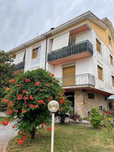 a building with a flowering tree in front of it at Casa Adele in Serravalle Scrivia