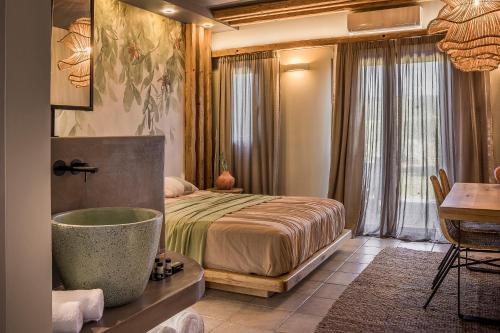 a bedroom with a bed and a bath tub and a desk at Avithos Resort Hotel in Svoronata