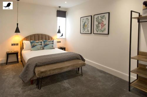 Schlafzimmer mit einem Bett mit einer Bank in der Unterkunft Blackbird Accommodation and Luxury Apartments room 15 in Blackpool