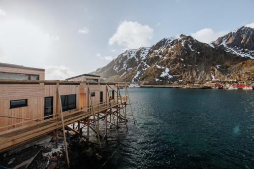a building on a pier next to a body of water at Hemmingodden Lodge in Ballstad