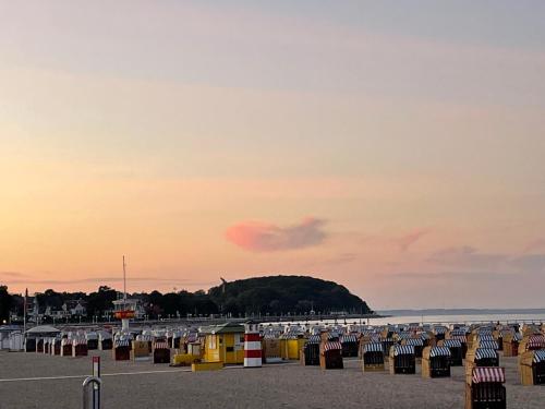 a row of trash cans on a beach at sunset at Gepflegtes und schönes Ferienapartment im Neubau in Travemünde