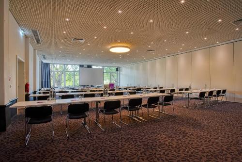 a large conference room with a long table and chairs at FourSide Plaza Hotel Trier, Trademark Collection by Wyndham in Trier
