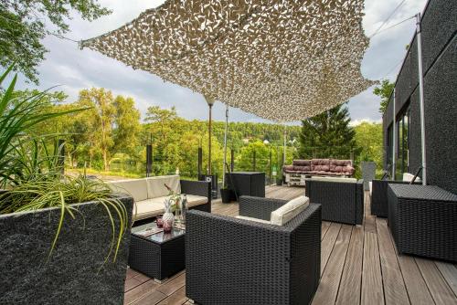 a patio with wicker chairs and an umbrella at FourSide Plaza Hotel Trier, Trademark Collection by Wyndham in Trier