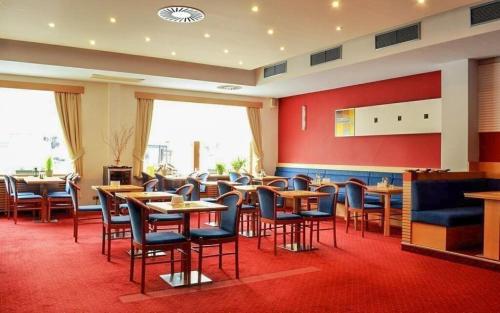 イェセニークにあるHotel Slovanのテーブルと椅子が備わるレストラン
