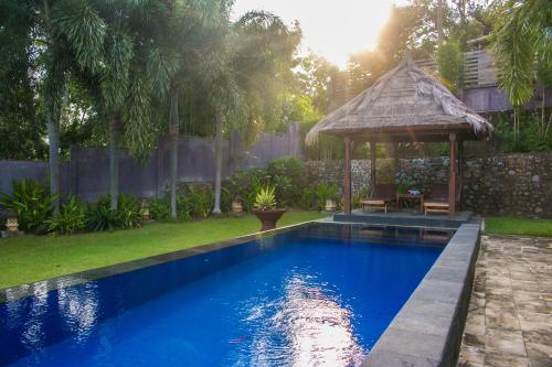a swimming pool with a gazebo in a yard at Imaj Private Villas in Senggigi 