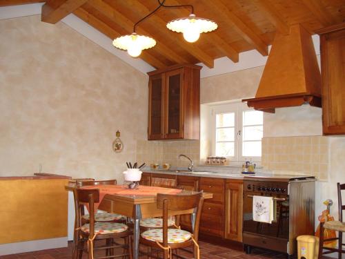 una cucina con tavolo in legno e piano cottura forno superiore di Il Podere Di Giada a Bagni di Lucca