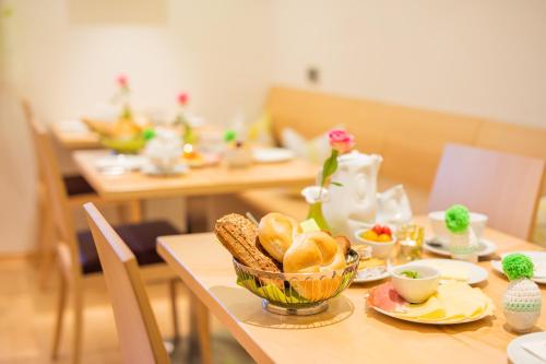 a table with a bowl of bread and vegetables on it at Haus Bergblick in Fuschl am See