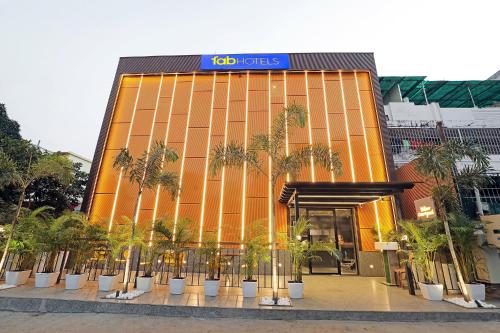 a building with palm trees in front of it at FabHotel Yellow Courtyard in Bhopal