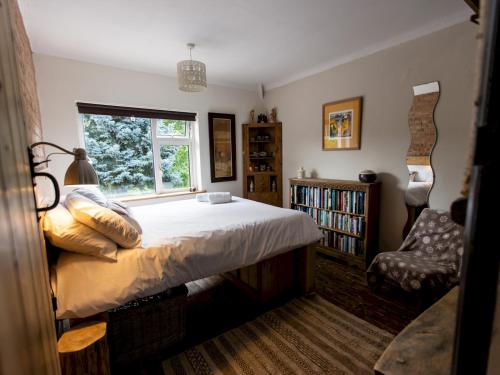 ein Schlafzimmer mit einem großen Bett und einem Fenster in der Unterkunft Pass the Keys Explorers Base Camp in Church Stretton