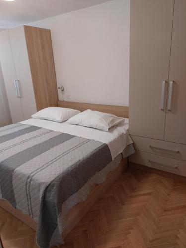 a bedroom with a bed and a white cabinet at Apartments Mlacovic in Rab