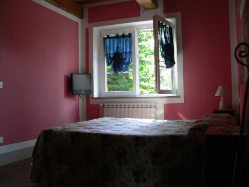 1 dormitorio con 1 cama y 2 ventanas en Il Podere Di Giada en Bagni di Lucca