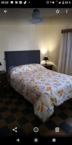 un letto con piumone in una camera da letto di La casita de Ana y Eto a Villa Elisa