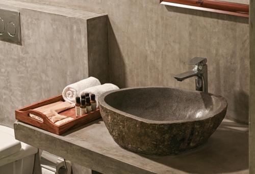 a bathroom with a large stone tub in a bathroom at Fireflies Kabini in Begūr