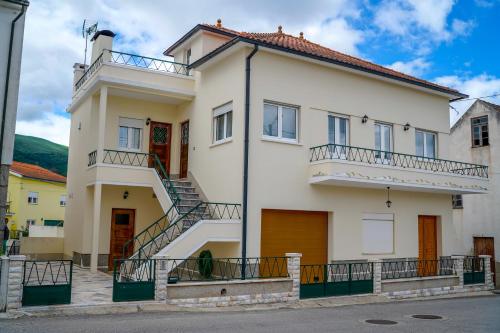 a large white house with stairs on it at Casa Origens in Seia