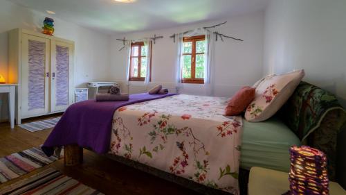 1 dormitorio con 1 cama con manta morada en Kuća za odmor Feniks 3, en Ravna Gora