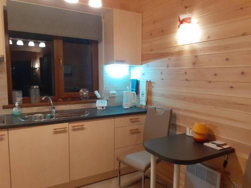 a kitchen with a table and a sink and a counter at Forest Edge Lodge in Riga