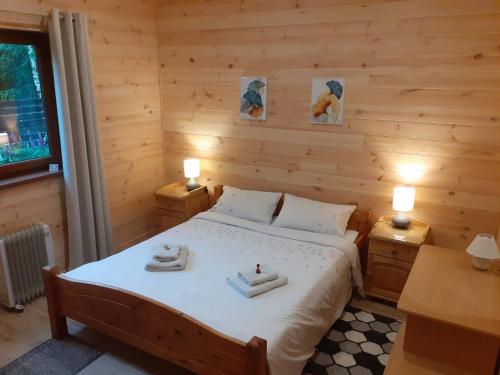 a bedroom with a bed with towels on it at Forest Edge Lodge in Riga