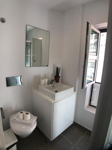 a white bathroom with a sink and a toilet at LX Lisboa Cozy studio in Lisbon