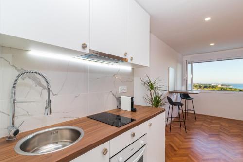 kuchnia ze zlewem i blatem z oknem w obiekcie TOP FLOOR MODERN APARTMENT WITH INCREDIBLE VIEWS w Puli