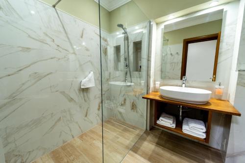 La salle de bains est pourvue d'un lavabo et d'une douche en verre. dans l'établissement Hotel AmaDeus, à Focşani