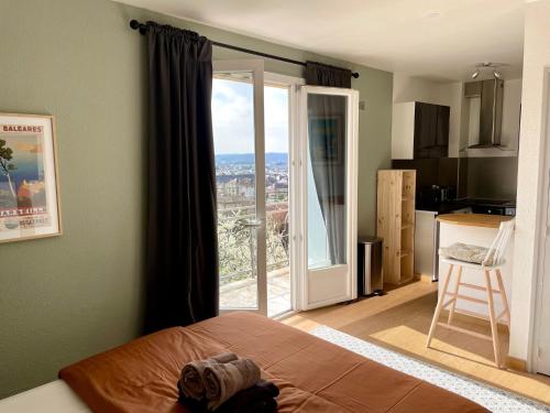 une chambre avec un lit et une vue sur une cuisine dans l'établissement Mon Appart'hôtel - Superbe Studio avec Parking Gratuit, à Brive-la-Gaillarde