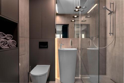 a bathroom with a toilet and a glass shower at Niegaleria Apartament in Wrocław