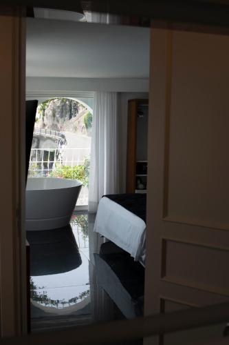 a bedroom with a bath tub and a window at Palazzo Don Salvatore in Amalfi