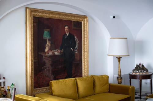 a painting of a man in a suit in a living room at Palazzo Don Salvatore in Amalfi