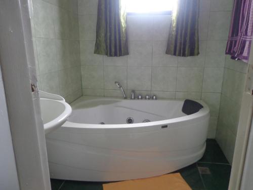 baño con bañera blanca y ventana en White Castle Hotel and Resort, en Balibago