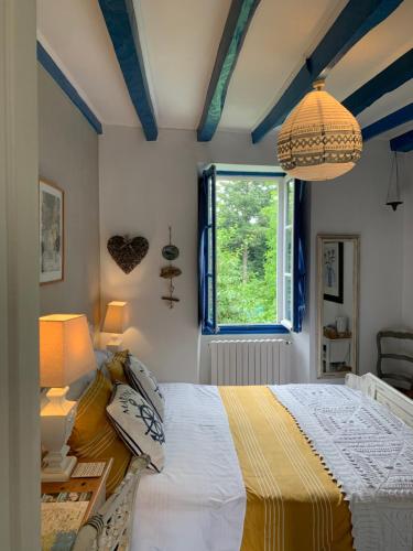 a bedroom with a bed and a window at Vingt Vieux Bourg in Rochefort-en-Terre