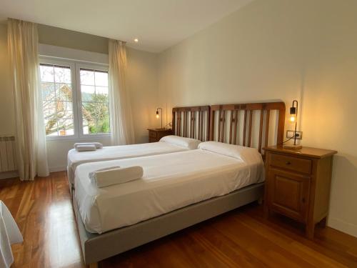 a bedroom with a large bed and a window at La Reserva de Los Campos in Cadavedo