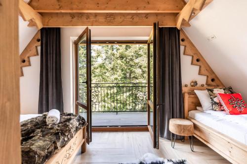 a room with a bed and a large window at Aparthotel Delta Royal in Kościelisko