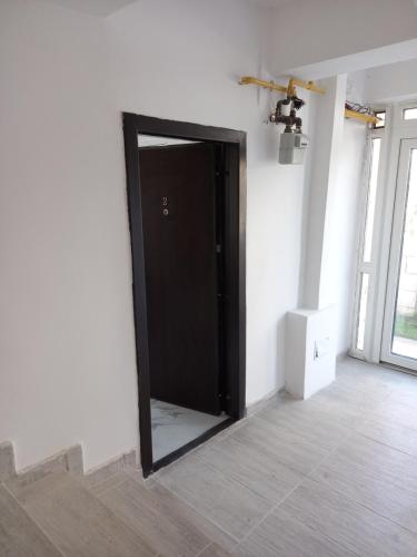 a black door in the middle of a room at Twins Residence 2 APART HOTEL AP 2 2 rooms in Chiajna
