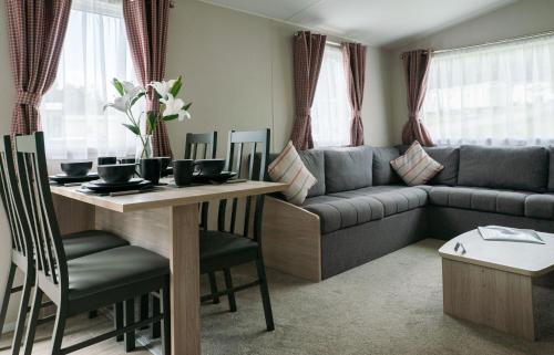a living room with a couch and a table at Woodside Hot Tub Retreat in Newton on the Moor