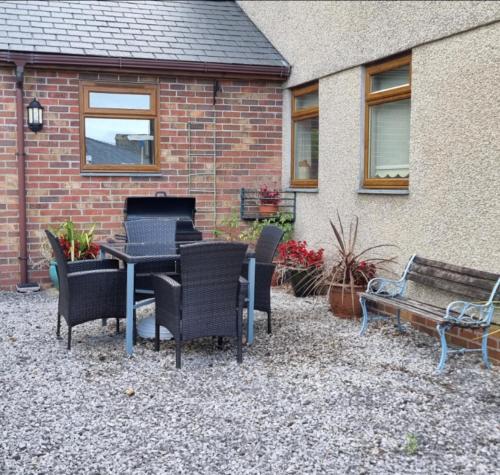 a patio with a table and chairs and a building at Criccieth Family holiday house in Tremadoc