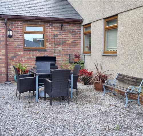 a patio with a table and chairs and a building at Criccieth Family holiday house in Morfa Bychan