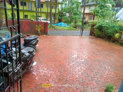 a red brick patio with a black fence and a gate at Palolem Sunrise Apartment in Palolem
