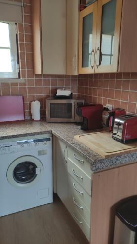 a kitchen with a washer and a counter top at Authentic Charm Soltroia in Troia