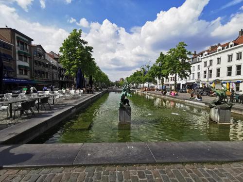 a canal in a city with people sitting around tables at Exclusive two-level apartment with private terrace on the canal Brussels in Brussels