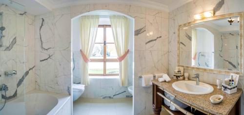 ein Badezimmer mit einem Waschbecken, einer Badewanne und einem WC in der Unterkunft Schloss Thalheim in Sankt Pölten