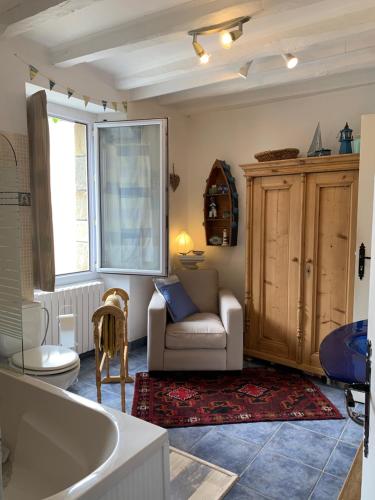 a living room with a tub and a couch and a chair at Vingt Vieux Bourg in Rochefort-en-Terre