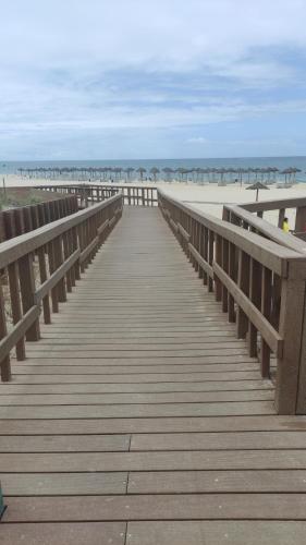 a wooden boardwalk leading to the beach at Authentic Charm Soltroia in Troia