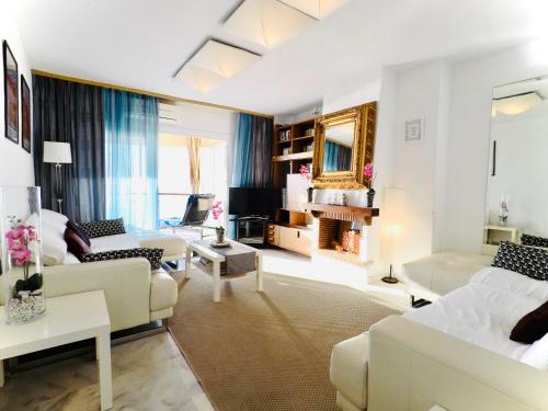 a living room with white furniture and a large window at Beach Apartment 3D - Fuengirola in Fuengirola