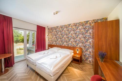 sypialnia z łóżkiem i dużym oknem w obiekcie Hotel Csillag Tokaj w Tokaju