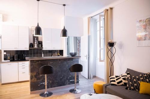 une cuisine et un salon avec des armoires blanches et des comptoirs noirs dans l'établissement Smile Apartment, à Cannes